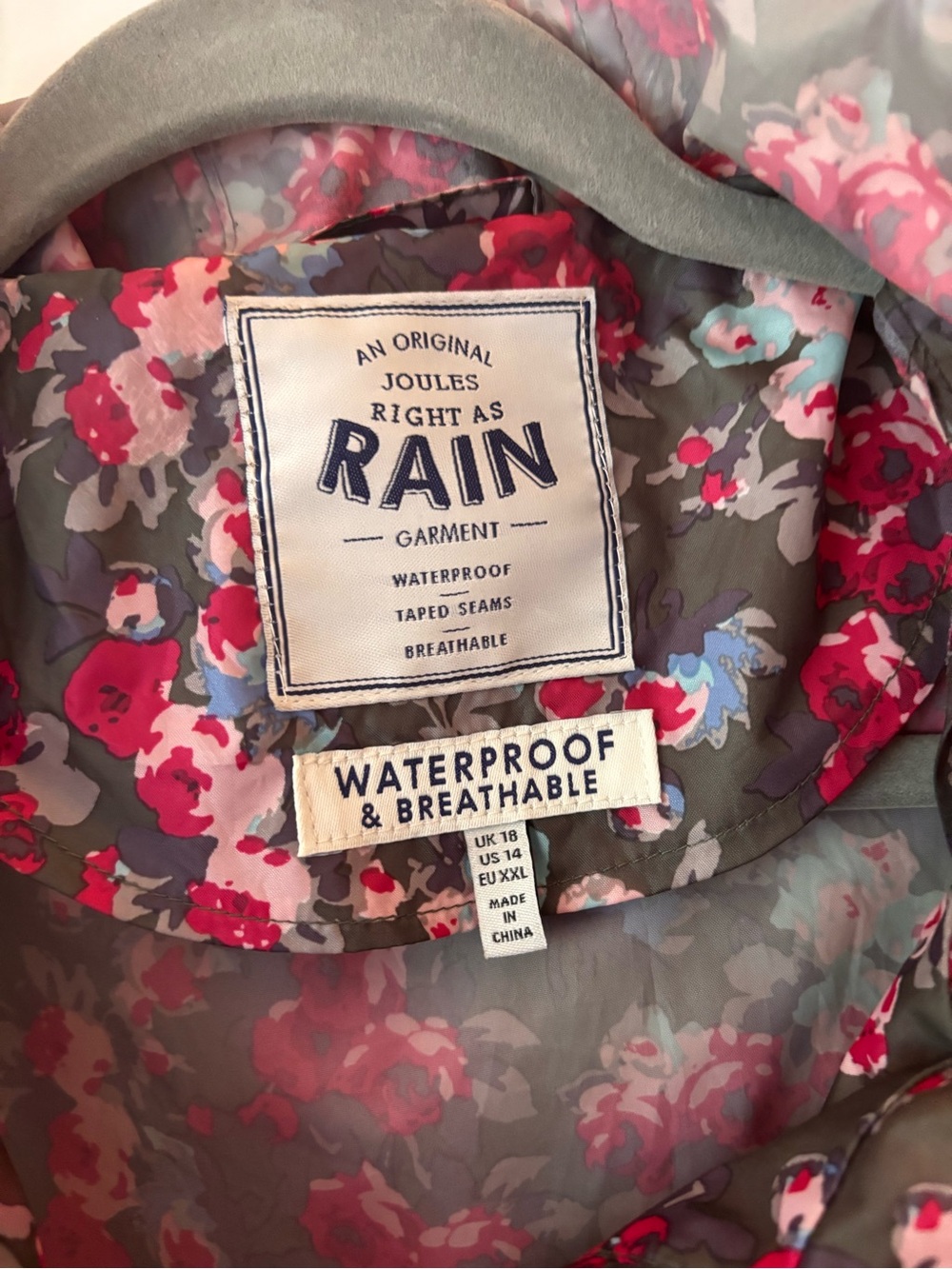 Joules Taupe Floral Rain Jacket with interior and exterior pockets.